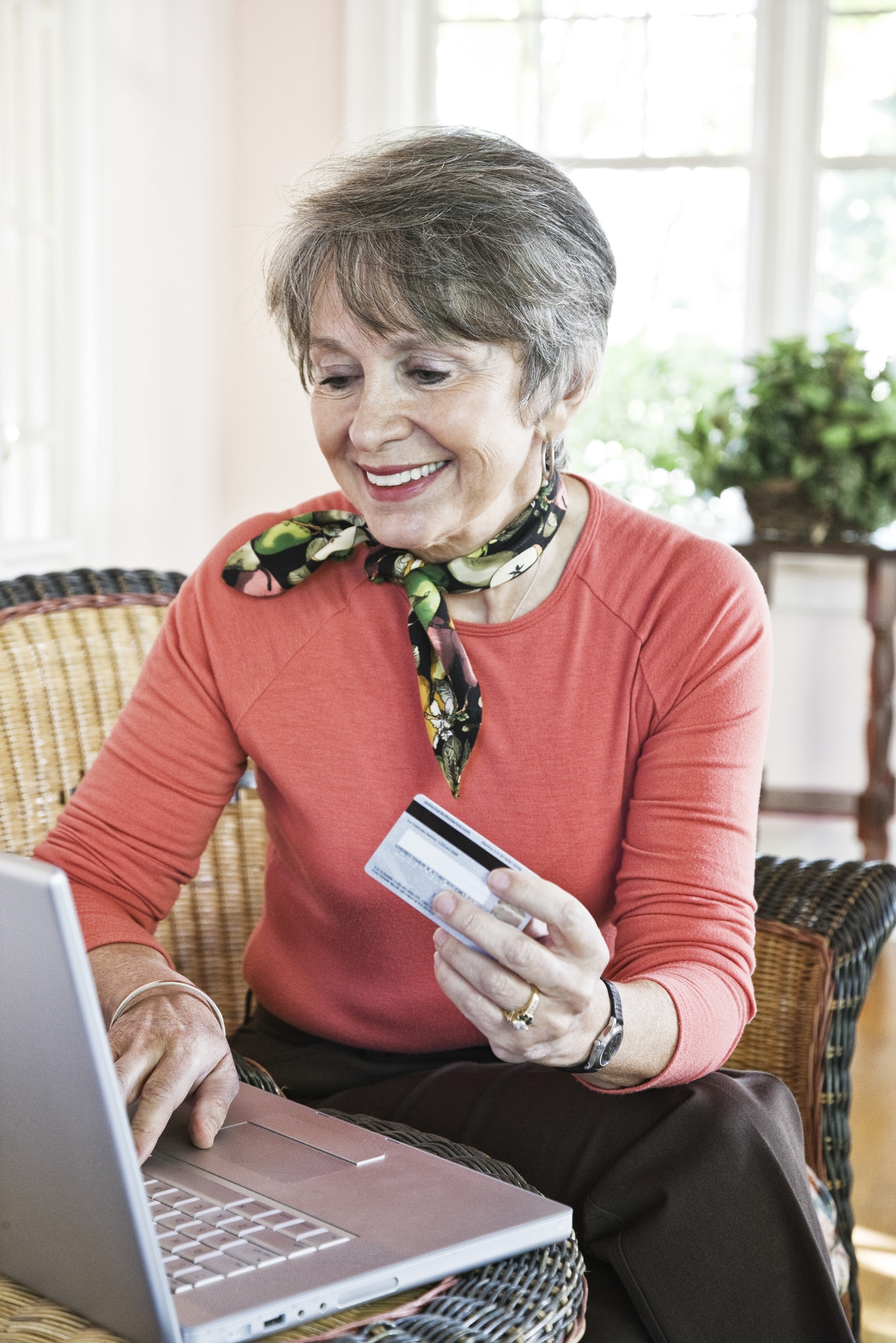 Senior woman buying a product online with a credit card.